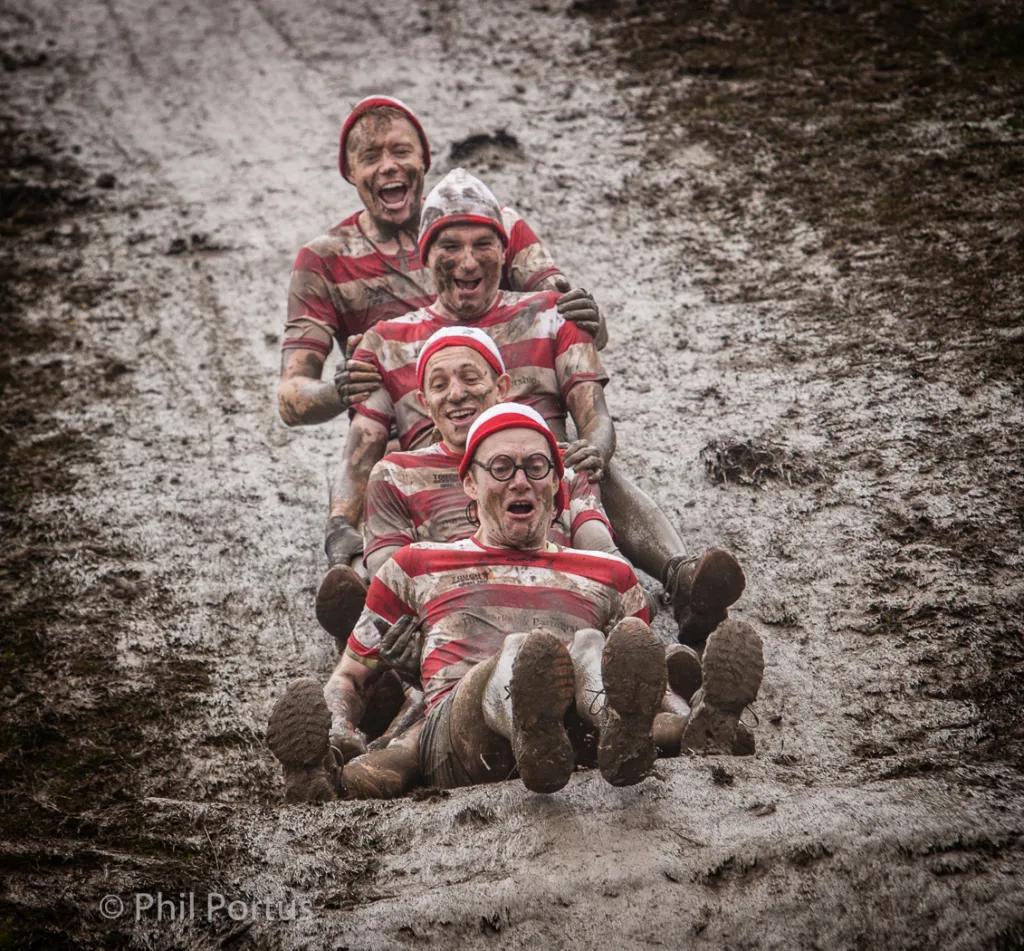 Mud Sliders. Friends enjoy a Tough Mudder event at Broughton Hall Estate, Yorkshire