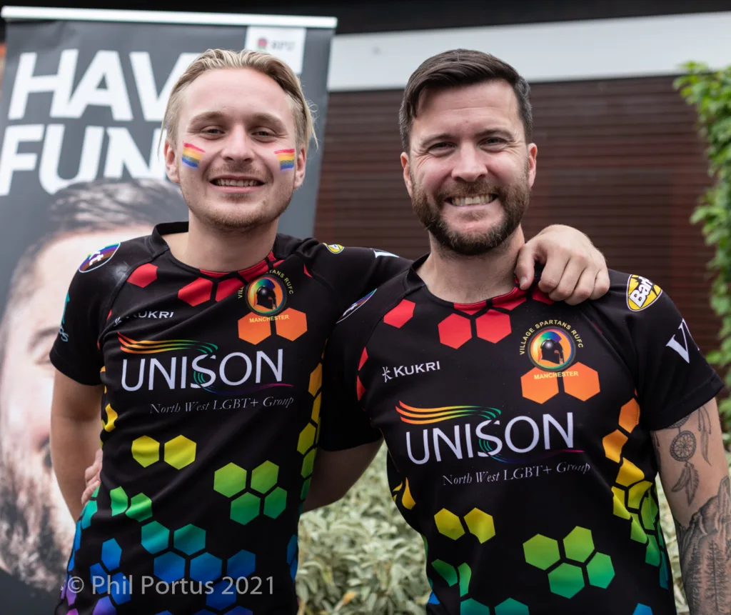 Two men with beards stand close together wearing matching athletic jerseys with colorful designs.